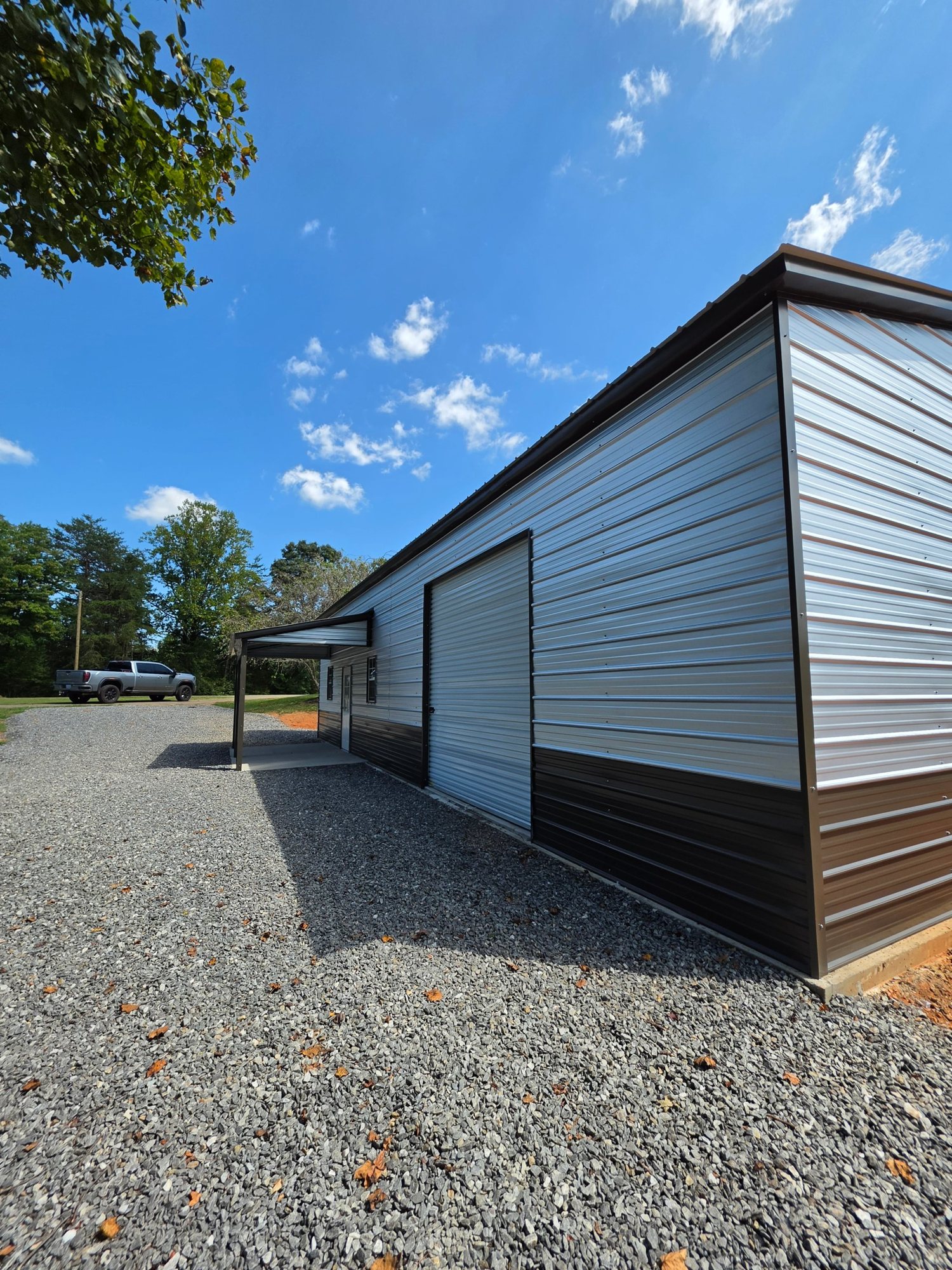 Side wall of the finished building with the roll-up door and two-tone metal siding